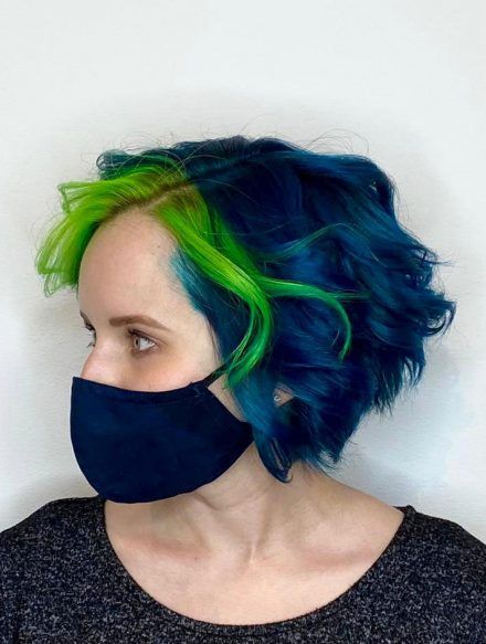 Side profile of model with deep blue hair and bright green highlights in the front.