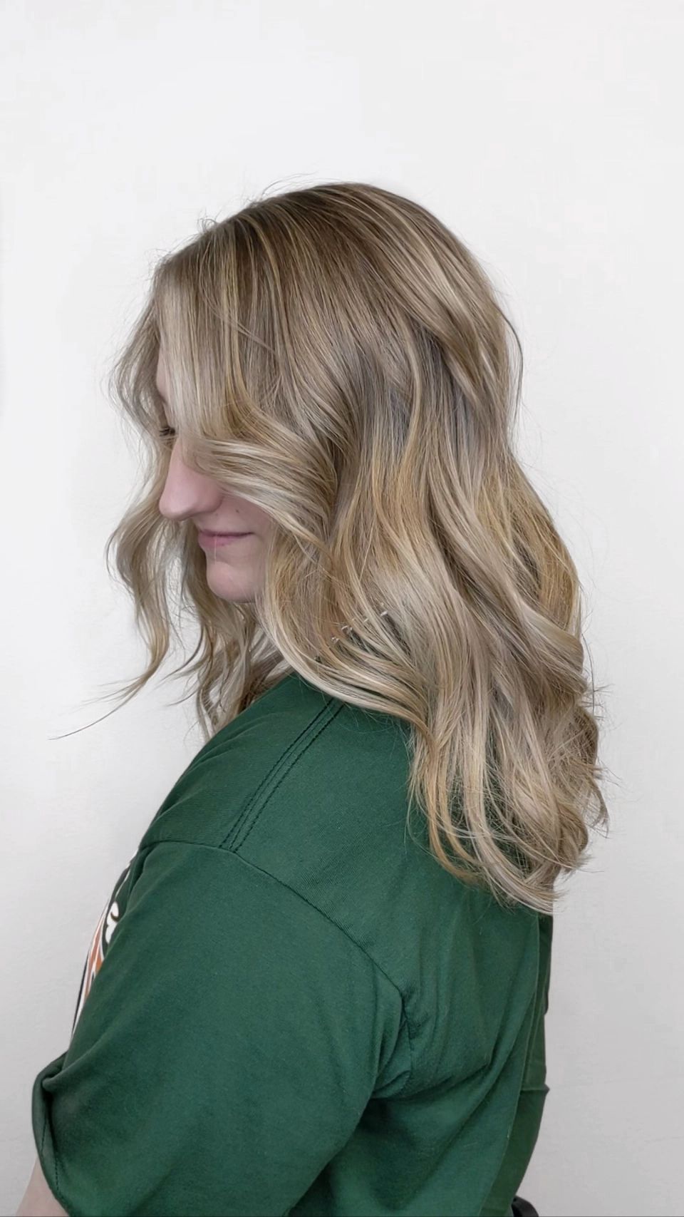 Woman showing her dirty blonde balayage highlights