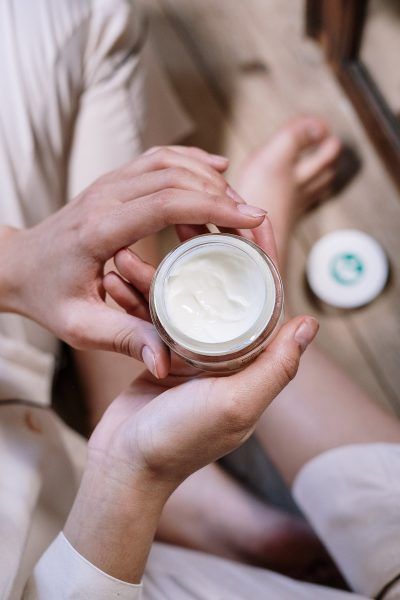 Downward view of woman holding skin moisturizer 